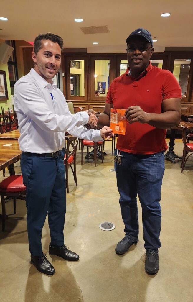 AAP Manager, Ali Khademian gifts a local landlord with a gift card to Home Depot.  One of the many giveaways at the AAP Landlord Dinner & Seminar